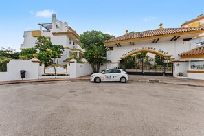 A gated entrance to a property with a white building and a sign that reads 'CALANOVA GRAND GOLF'.