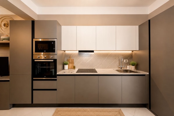 Eine moderne Küche mit integrierten Geräten, einer zentralen Kochinsel und einem minimalistischen Design.