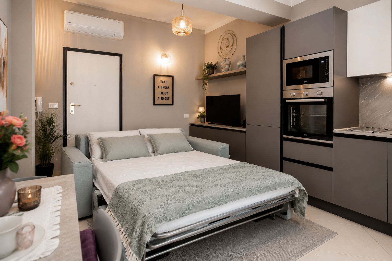 A modern bedroom with a bed, bedside table, and a built-in TV.