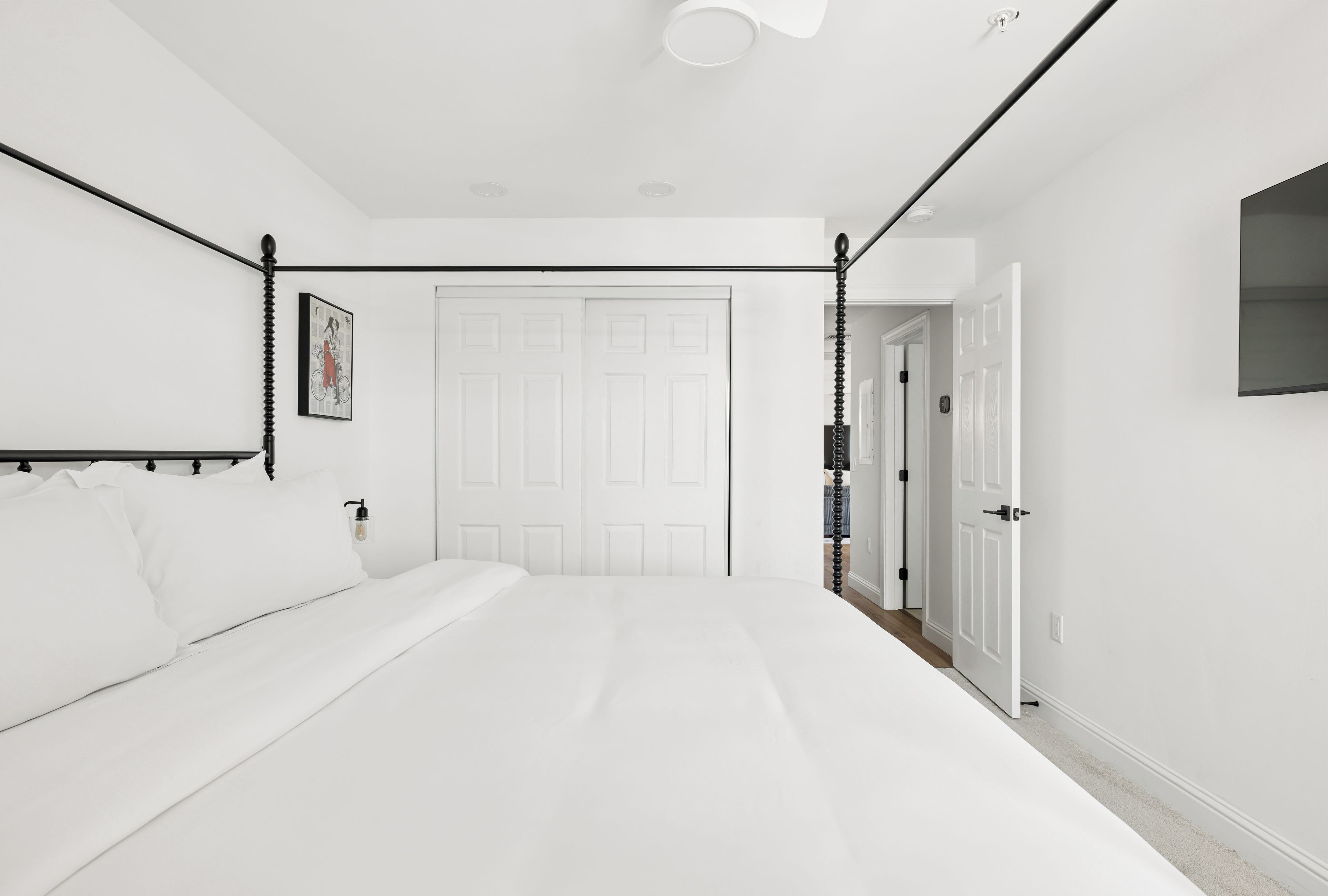 Ein Schlafzimmer mit einem Bett, einer Tür und einer Wandleuchte.