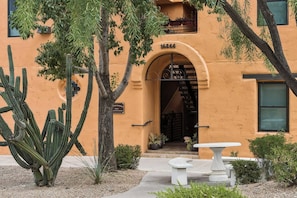 Un bâtiment doté d’une entrée en arc de cercle, d’une plaque numérotée et d ’un jardin de cactus.