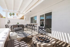 An outdoor patio area with a fire pit, seating, and a dining setup. - Sol & Stone: Old Town Condo with Hot Tub & EV (Scottsdale)