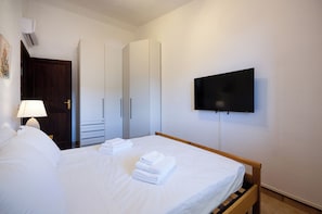 A hotel room with a bed, a TV mounted on the wall, and a wardrobe. - Cactus Apartments. 200 meters from the beach. Ocean view. (Solanas)