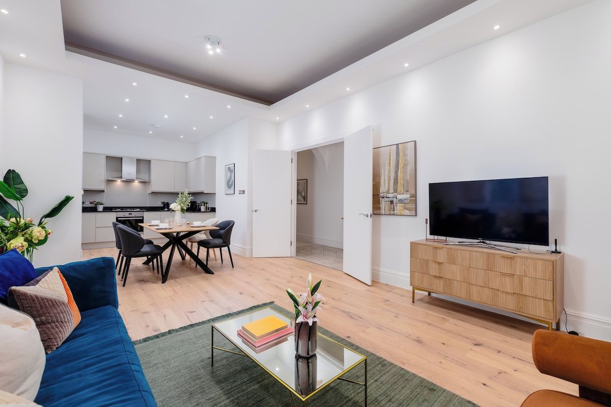 A modern living room with a sofa, coffee table, and a flat-screen TV.