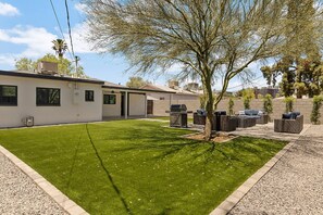 A residential property with a well-maintained lawn, outdoor seating area, and a garage. - The Elliott at Biltmore | Fire Pit, Grill (Phoenix)