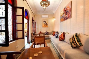Una sala de estar con un sofá, una mesa de centro y un cuadro en la pared.