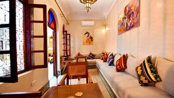 Una sala de estar con un sofá, una mesa de centro y un cuadro en la pared.