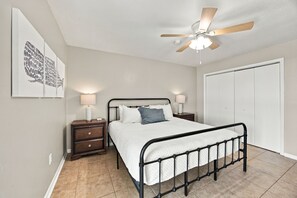 A bedroom with a bed, nightstands, a ceiling fan, and a wardrobe. - Beachfront 2BR Condo w/ Gulf views, pool & direct beach access! (Gulf Shores)