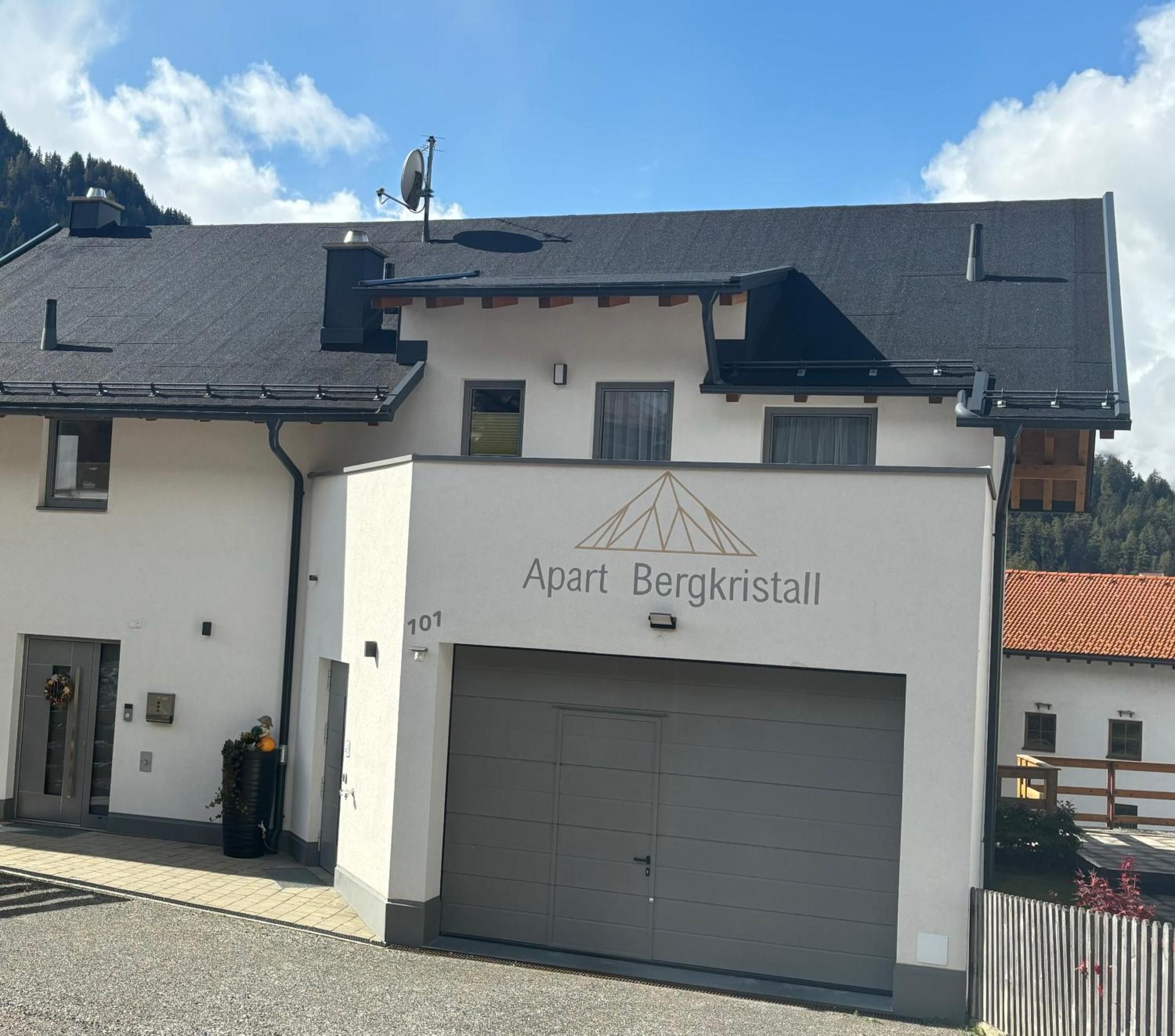 Un edificio con un letrero que dice 'Apart Bergkristall' y una puerta de garaje.