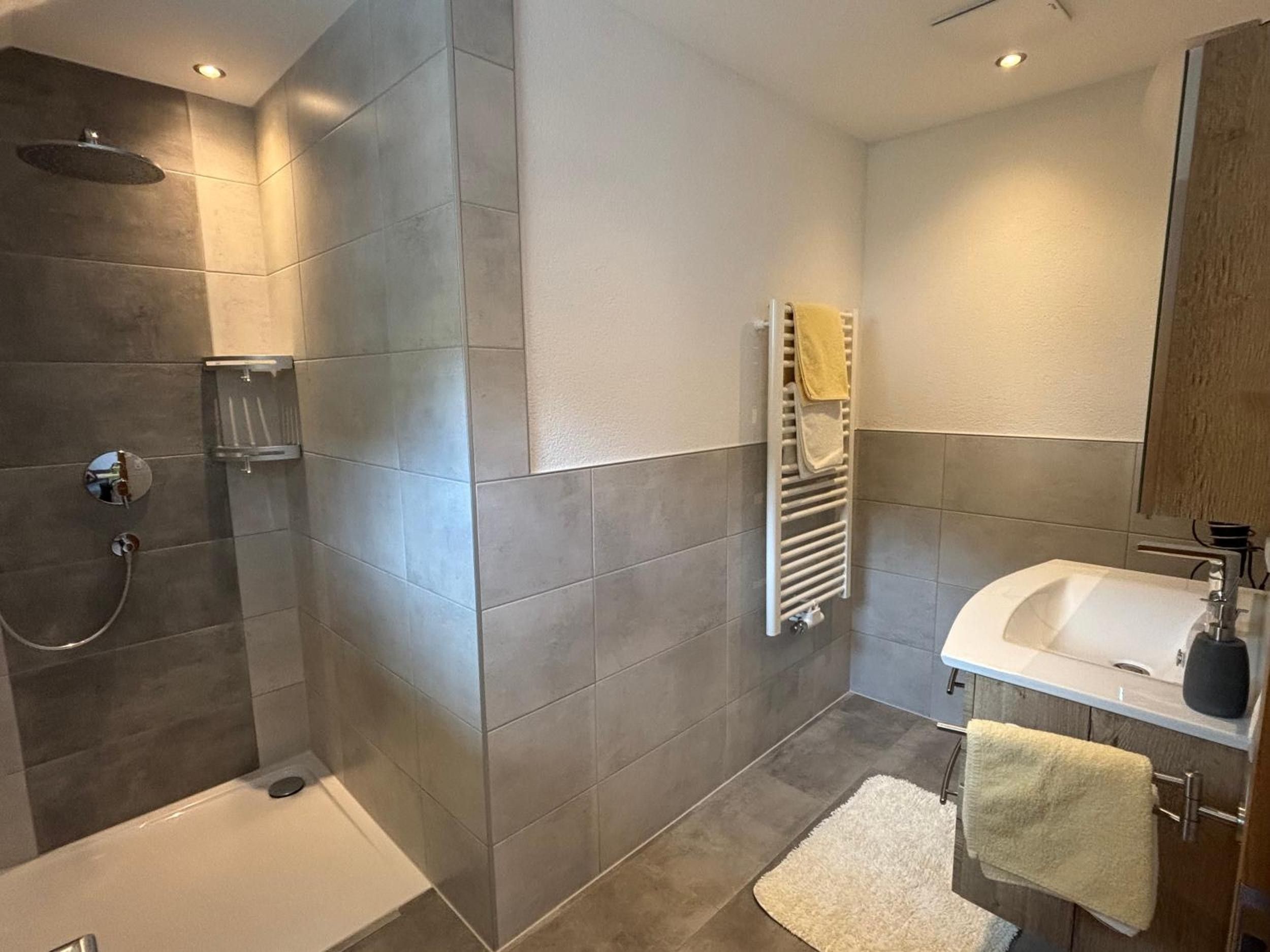 Un baño moderno con una bañera, una ducha y un lavamanos.