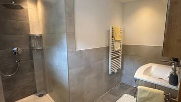 Un baño moderno con una bañera, una ducha y un lavamanos.