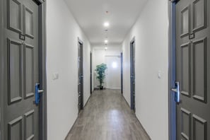Corredor com portas numeradas 210 e 205, dando acesso a quartos.