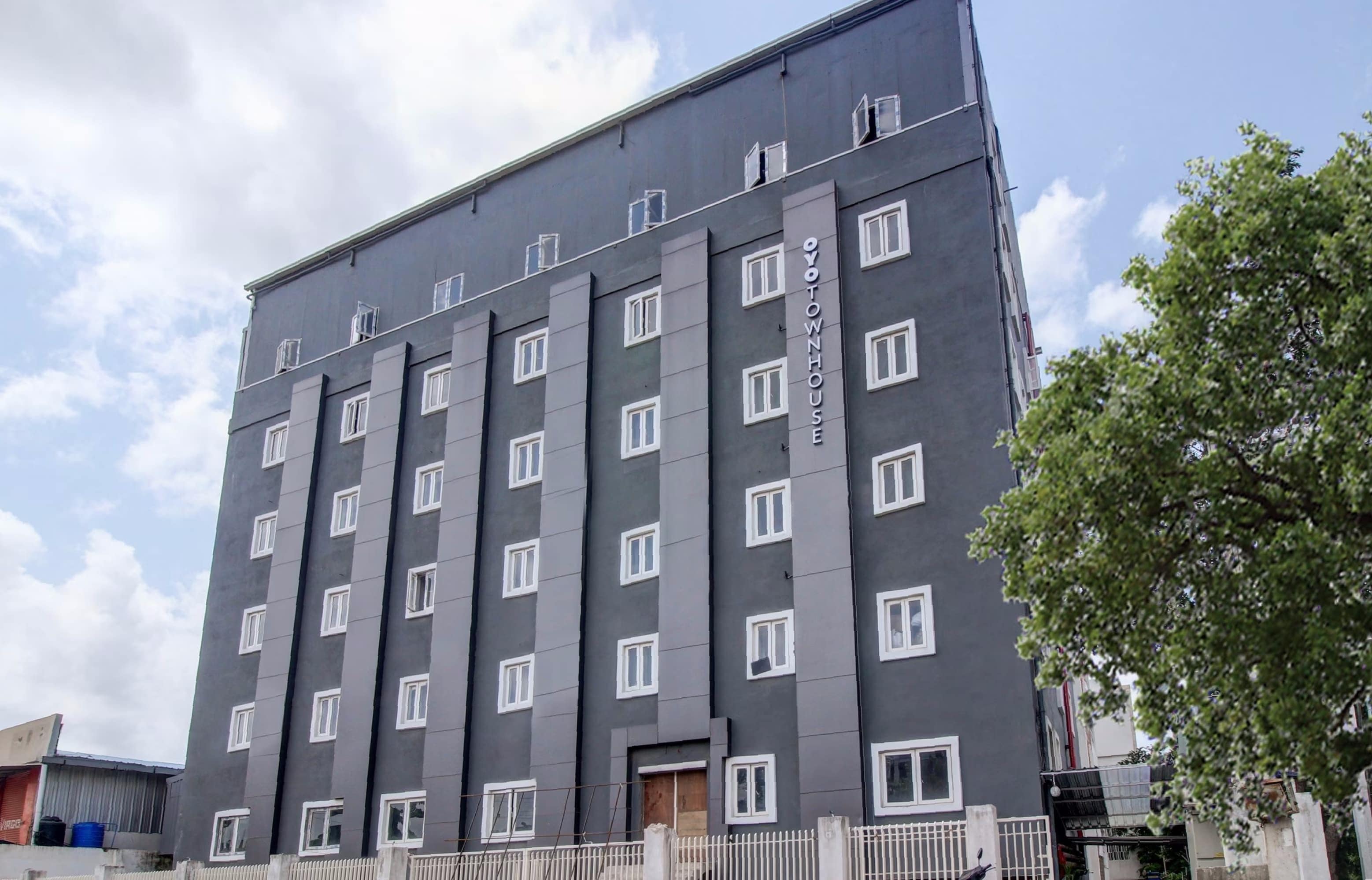 A multi-story building with a grey facade and white-framed windows.