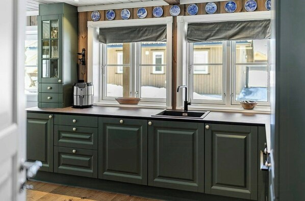 A kitchen with a window, a sink, and a cabinet.