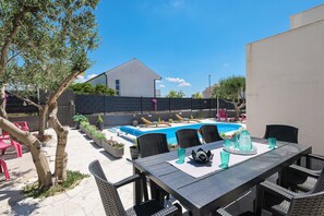 A backyard with a swimming pool, outdoor furniture, and potted plants. - Villa Feliks ZadarVillas (Ljubac)