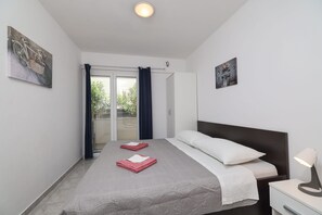 Une chambre à coucher avec un lit, une table de chevet, une lampe et deux tableaux accrochés aux murs.