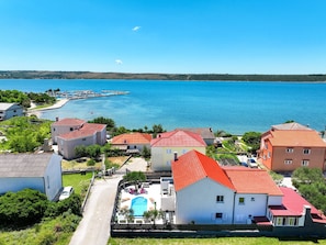 A coastal residential area with houses, a swimming pool, and a clear view of the sea. - Villa Feliks Zadarvillas (Razanac)