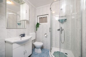 A modern bathroom with a glass shower enclosure, a white sink, and a toilet. - Villa Feliks Zadarvillas (Razanac)