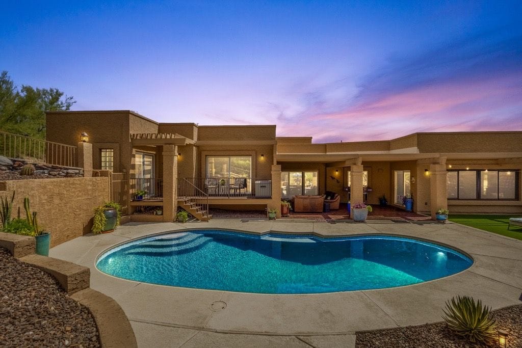 A residential property with a swimming pool, outdoor seating, and a landscaped garden.