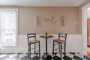 A dining area with two chairs, a table, and wall-mounted cutlery. - Historic 1851 Downtown Elizabethtown Home (Elizabethtown)