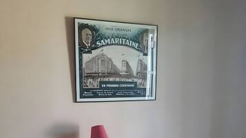 Une pièce comprenant un lit, une commode, une lampe et un tableau encadré accroché au mur.