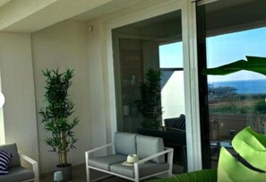 A balcony with a chair, a potted plant, and a view of the ocean. - Room 'Camera Tripla Con Vista Mare' with Sea View, Wi-Fi and Air Conditioning (Salerno)