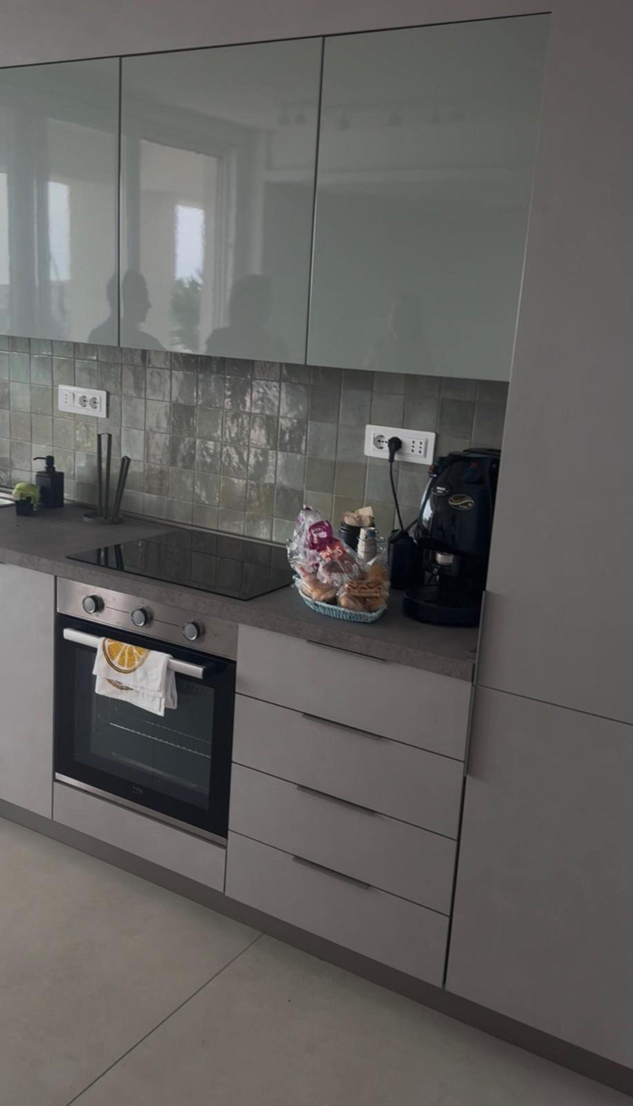 Uma cozinha com forno embutido, pia e máquina de café.