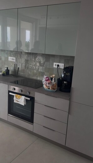 Una cucina con forno integrato, lavandino e macchina da caffè.