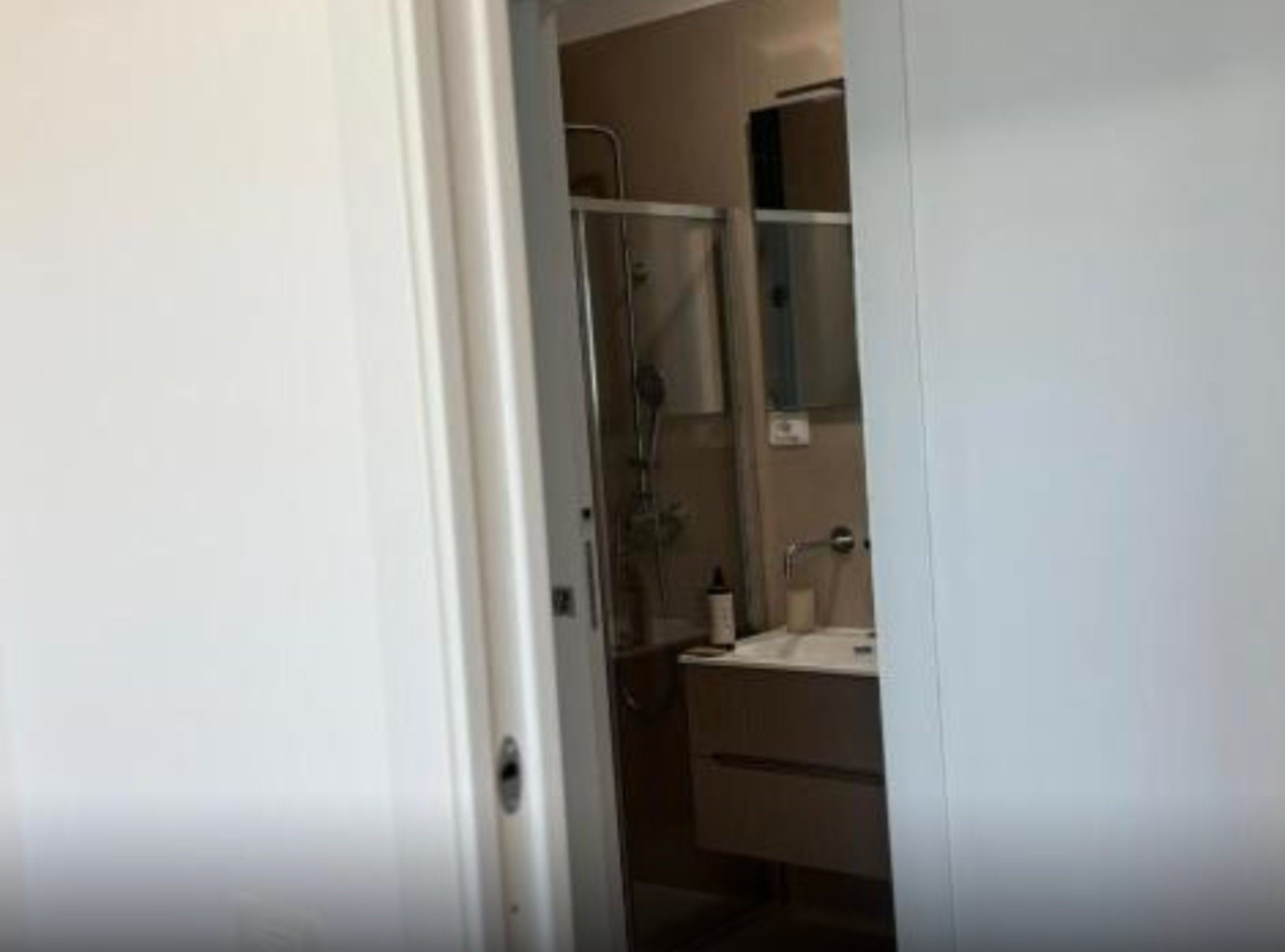 A bathroom with a shower, sink, and mirror.