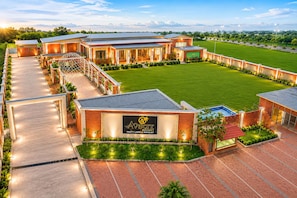 A modern resort with multiple buildings, a well-maintained lawn, and a clear sky.