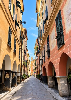 A narrow street flanked by historic buildings with arched doorways and a central tower. - Studio 'In Caruggio' with Wi-Fi and Air Conditioning (Chiavari)