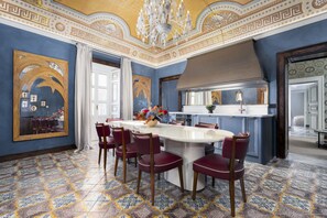 A dining area with a large oval table, red chairs, and a decorative ceiling. - Dimora Italia Blu Calypso Ortigia (Ortigia)