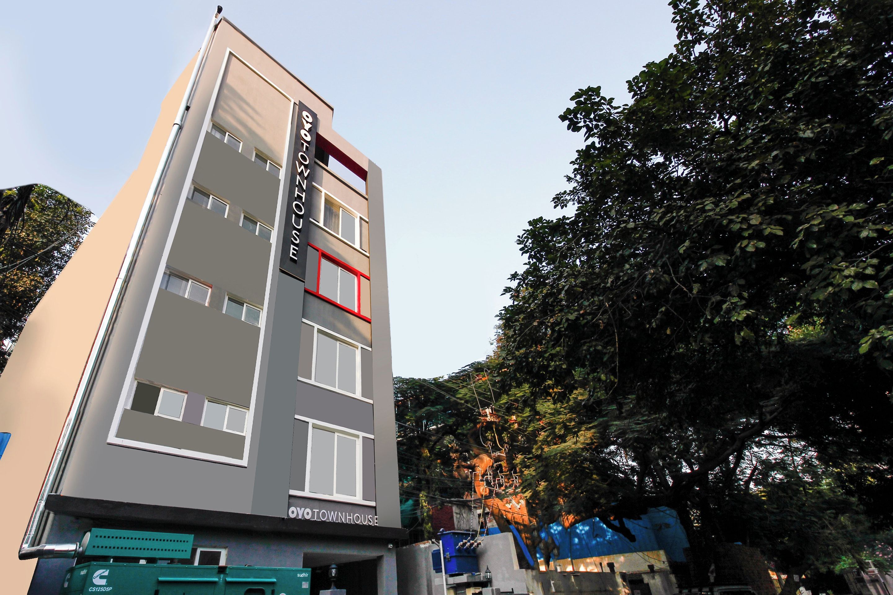 Um hotel de vários andares com design moderno, exibindo uma placa grande no topo.