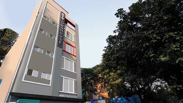 Um hotel de vários andares com design moderno, exibindo uma placa grande no topo.