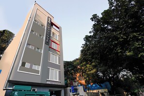 Un hotel urbà de diverses plantes amb un disseny modern, que destaca un senyal prominent al capdamunt.