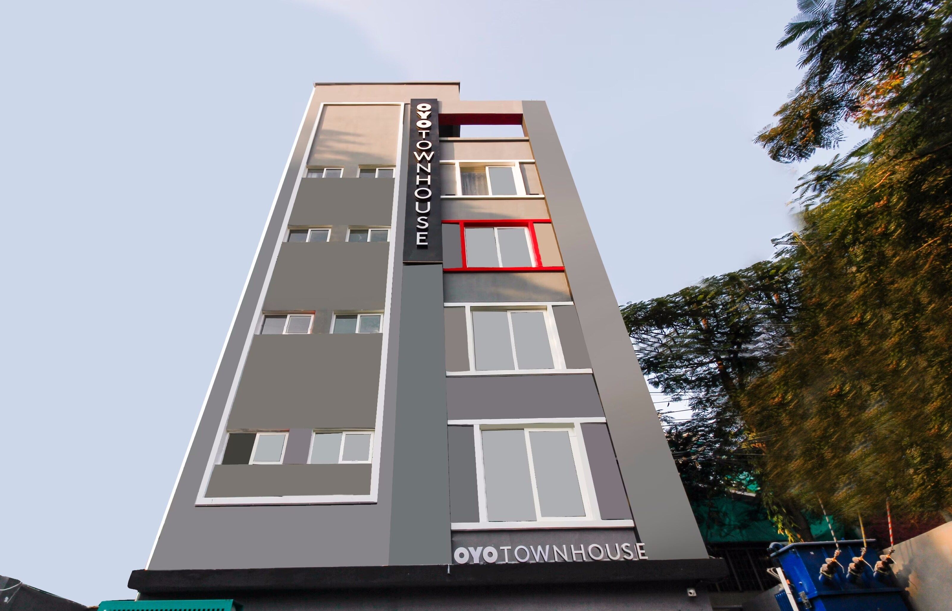 A multi-story building with a sign reading 'OYOTOWNHOUSE' on the facade.