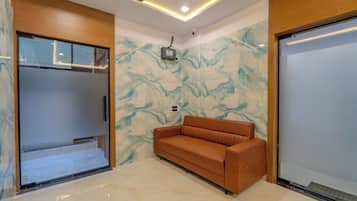 Ein Zimmer mit einer Couch, einem Deckenventilator und einer Wand mit Marmormuster.