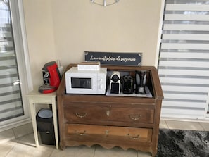 Eine Küchenzeile mit Kaffeemaschine, Mikrowelle, Toaster und einem Schild an der Wand.