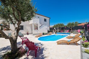 A pool area with lounge chairs and a tree. - Villa Feliks Zadarvillas (Razanac)