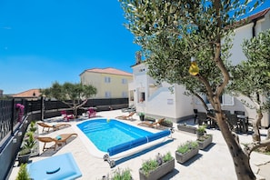 A residential property with a swimming pool, outdoor seating, and a tree. - Villa Feliks Zadarvillas (Razanac)
