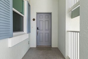 A grey door with a keypad lock, a small sign with the number 155, and a window with blue shutters. - Cinnamon Beach 5th floor ocean condo 155 - incredible views! (Palm Coast)
