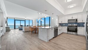 A modern kitchen with a large island, built-in appliances, and a view to the outdoors. - Unreal Views from this Beachfront 4BR Beauty! (Gulf Shores)
