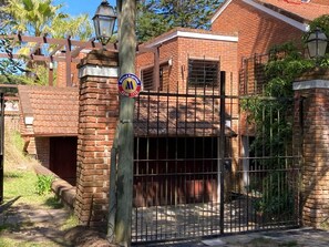 A gated property with a brick building, a metal gate, and a street lamp.