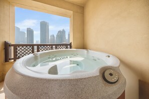 Un jacuzzi con vista a un paisaje urbano a través de una ventana.