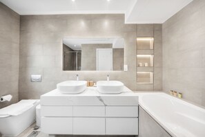 A modern bathroom with two sinks, a bathtub, and a shower. - StayShort - Fabulous 2-Bedroom at Al Tajer in Downtown with Easy Access to Dubai Mall (Downtown Dubai)