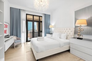 A modern hotel room with a large bed, a desk, a chair, a TV, and a view of the city through the window. - StayShort - Fabulous 2-Bedroom at Al Tajer in Downtown with Easy Access to Dubai Mall (Downtown Dubai)