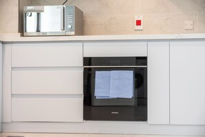 Cozinha com micro-ondas na bancada, forno Siemens e toalha pendurada na porta do forno.