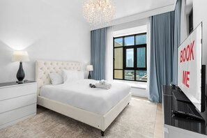 Ein modernes Hotelzimmer mit einem großen Bett, einem Fernseher und Blick auf die Stadt.