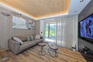 Una sala moderna con sofá, mesa de centro y televisor.