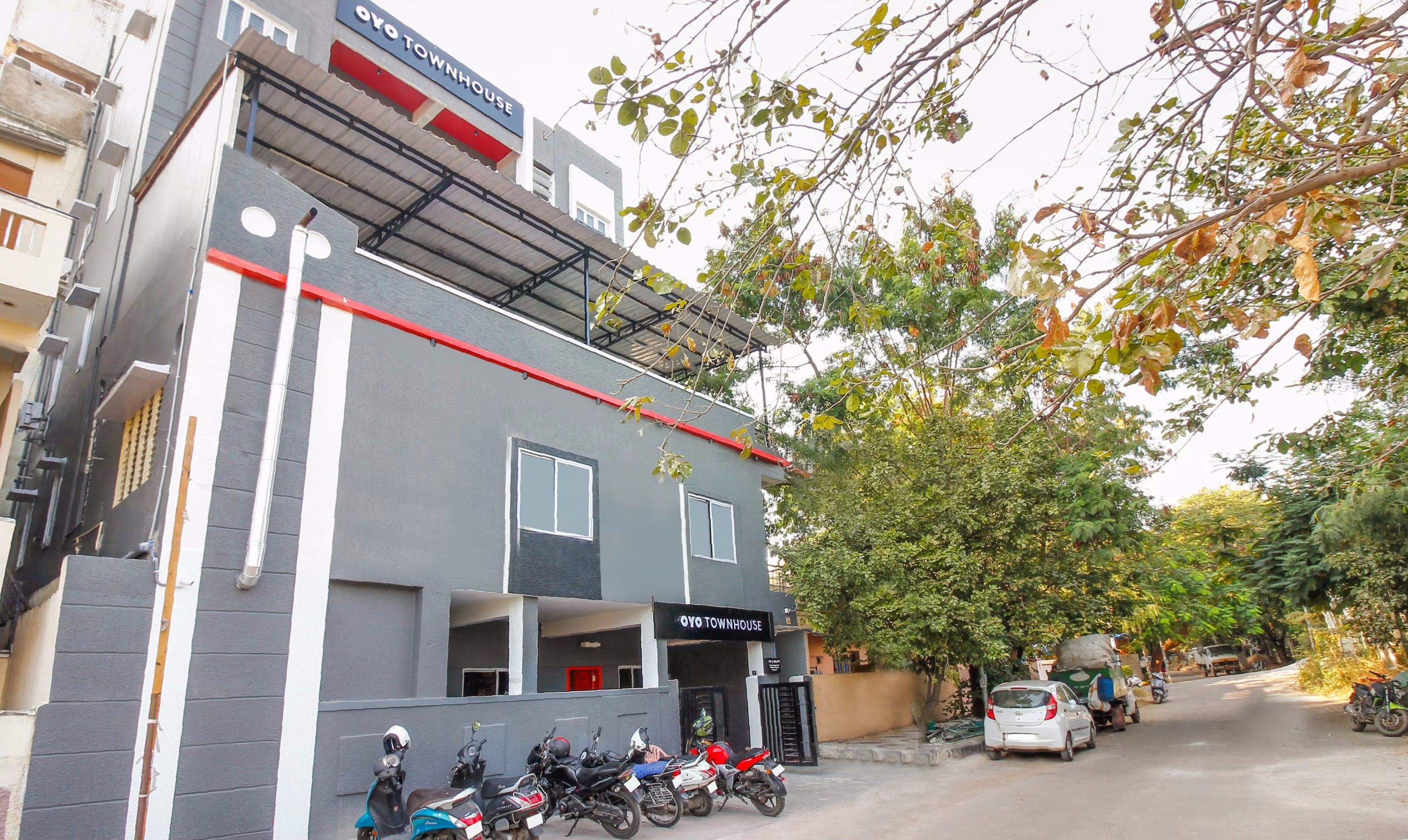 Un edificio con un cartel que dice 'OYO TOWNHOUSE' y una entrada cubierta.